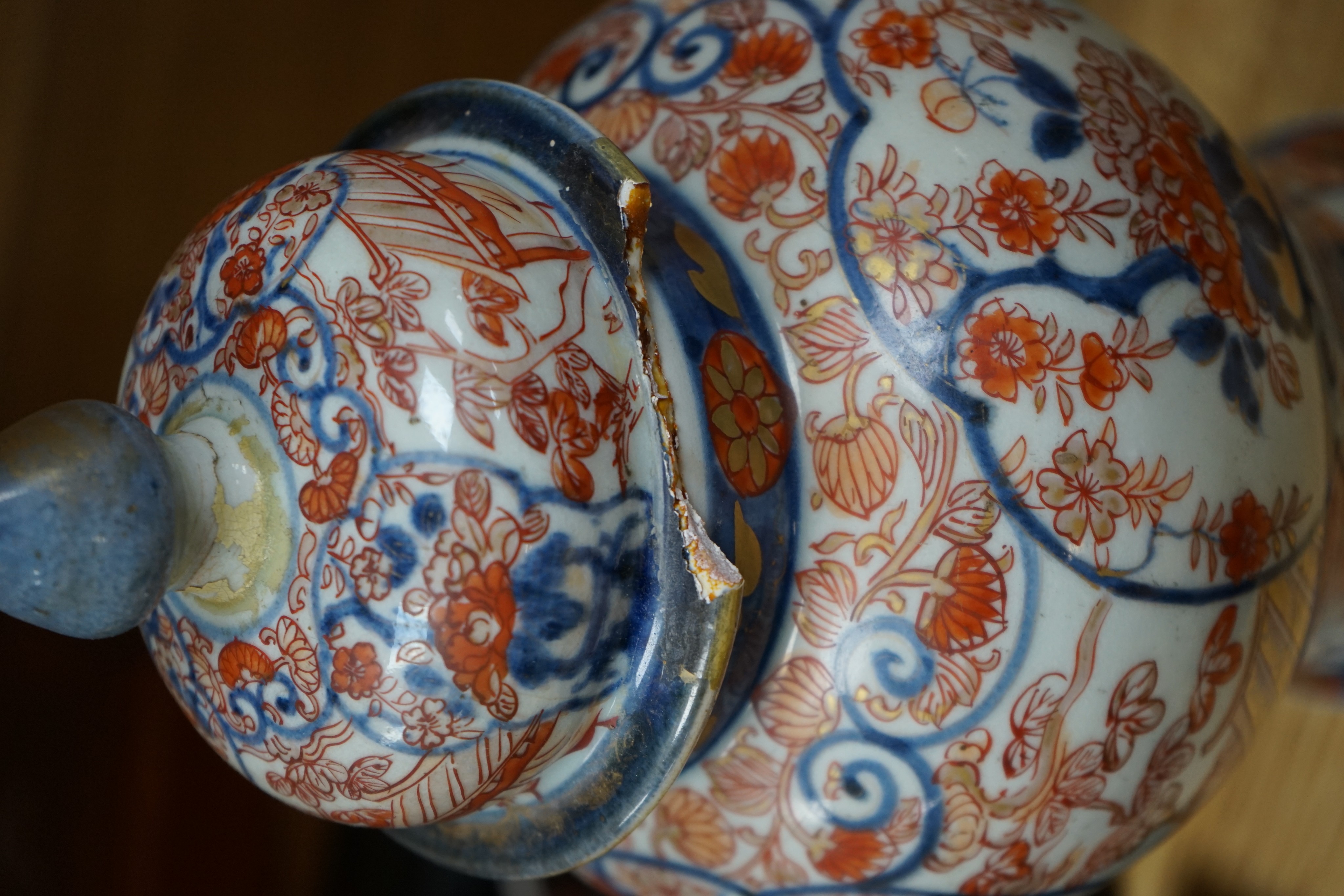 Three 18th century Japanese Arita baluster vases and covers decorated with flowers in urns (damage to covers) 29cm